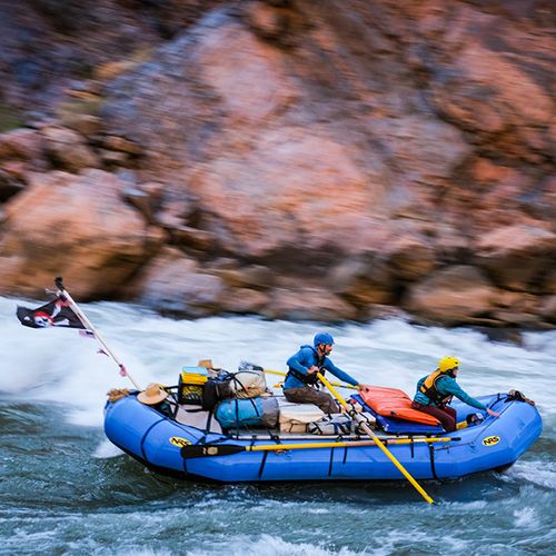 Rafters in a strong current with a pirate flag flapping behind